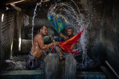 Hand Wash Batik factory workers applying stamps with repeating patterns © Roberto Pazzi