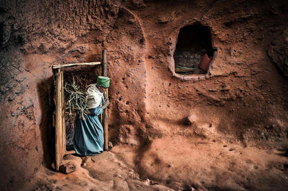 The Secret Passage Woman carrying a daily load of firewood for heating inside one of the rock-hewn monolithic churches in Lalibela © Roberto Pazzi