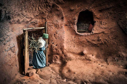 The Secret Passage Woman carrying a daily load of firewood for heating inside one of the rock-hewn monolithic churches in Lalibela © Roberto Pazzi