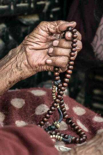 Worship Detail of the hand of an elderly Buddhist nun at prayer © Roberto Pazzi