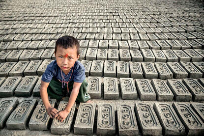 The Young worker Portrait of a child among raw bricks to dry in the sun at a brick factory © Roberto Pazzi